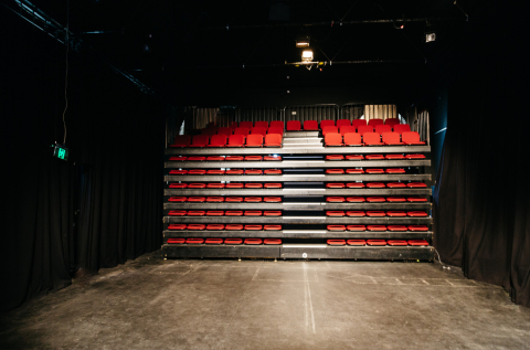 Theatre with retractable seats pushed back. View from stage. 